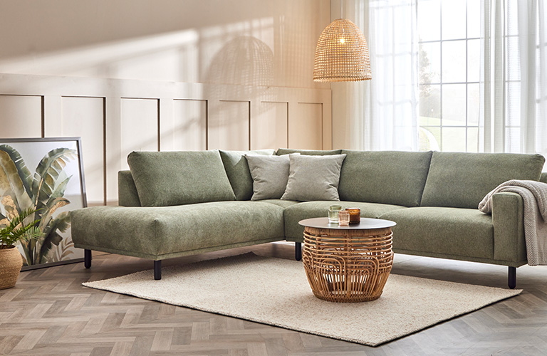 Rohkea sisustaja valitsee vihre&auml;n sohvan olohuoneeseensa.